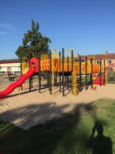 Groot rood met geel klimtoestel met glijbaan in het zand geplaatst - Klimtoestellen met glijbaan - Speeltoestellen - LuduQ speeltoestellen